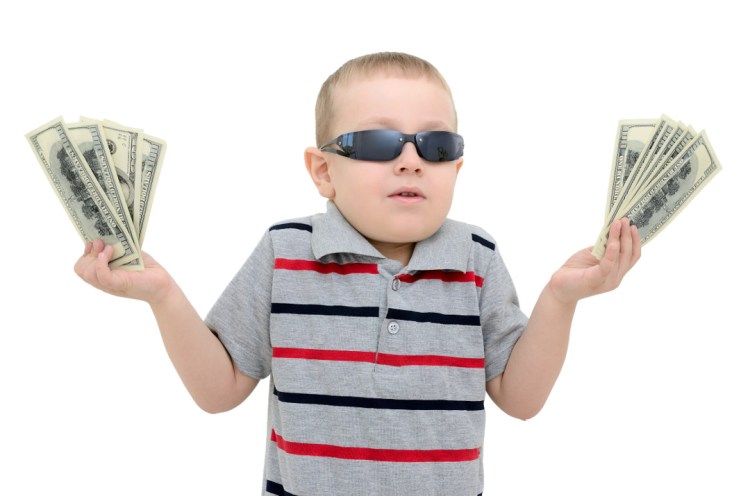Boy in amazement holding money on white background